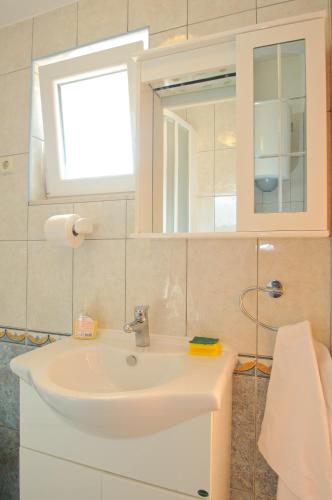 a bathroom with a white sink and a mirror at Apartments Šime in Trogir