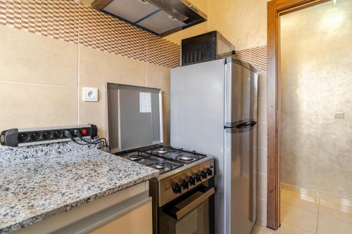 a kitchen with a stove and a refrigerator at luxury appartement near gueliz voyageurs in Marrakech