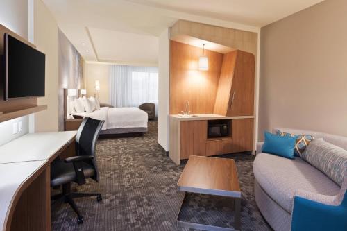 a hotel room with a bed and a desk and a couch at Courtyard by Marriott San Angelo in San Angelo
