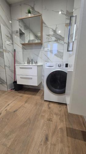 a bathroom with a washing machine and a sink at Studio u Arka in Kłodzko