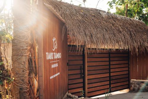 a hut with a thatch roof and a door at Taki Tambo Lodge in Tarapoto