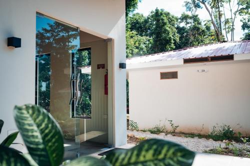 a pivot door to a house with a window at Taki Tambo Lodge in Tarapoto