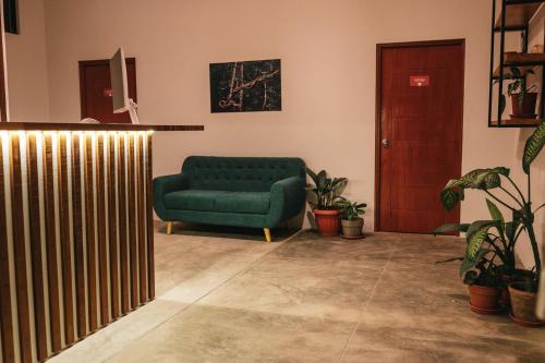a living room with a green couch and potted plants at Taki Tambo Lodge in Tarapoto