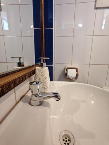 a white sink with a faucet and a mirror at Afma Cusco in Cusco