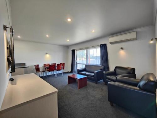 a waiting room with couches and chairs and a table at Camden Court Apartment in Invercargill