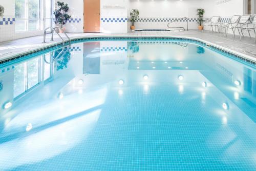 a swimming pool in a hotel with blue tiles at Fairfield Inn & Suites Canton in North Canton