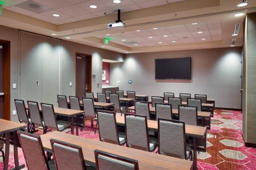 a conference room with tables and chairs and a screen at Courtyard by Marriott Salt Lake City Downtown in Salt Lake City