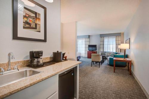 a kitchen with a sink and a living room at Courtyard Raleigh Crabtree Valley in Raleigh