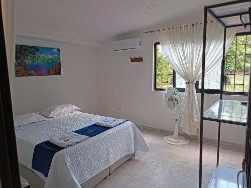 a white bedroom with a bed and a window at HOTEL POSADA CAMPESTRE SAN JUAN in Monterrey