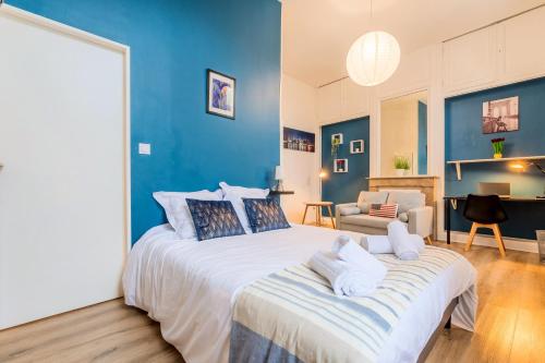 une chambre avec un grand lit aux murs bleus dans l'établissement Le Relais de la Poste Roubaix 6ch 6 sdb, 12 pers Centre Fibre, à Roubaix