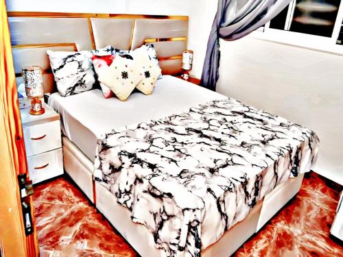 a small bedroom with a bed and a dresser at Luxury 3-bedroom apartments 5-min to the Airport in Fès