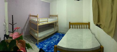 a bedroom with two bunk beds and a blue carpet at Recanto costacastilho in Bertioga