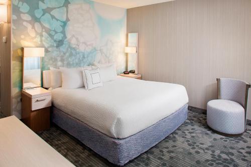 a hotel room with a bed and a chair at Courtyard by Marriott Richmond Airport in Sandston