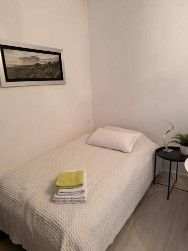 a bedroom with a bed with a green towel on it at Modernes 1 Zimmerapartment nahe Frankfurt am Main in Heusenstamm