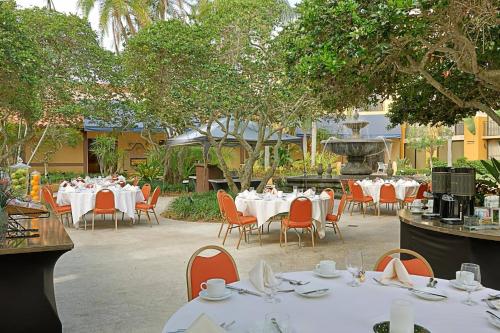 a restaurant with white tables and chairs and a fountain at Courtyard by Marriott Bradenton Sarasota/Riverfront in Bradenton