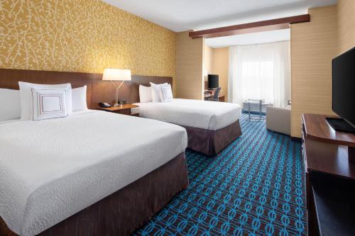 a hotel room with two beds and a television at Fairfield Inn & Suites by Marriott Poplar Bluff in Poplar Bluff