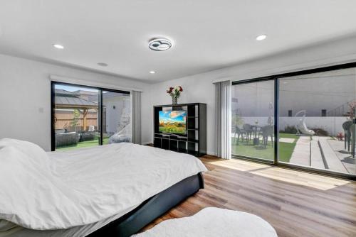 a bedroom with a large bed and a flat screen tv at Luxury 4 bedroom villa in Huntington Beach