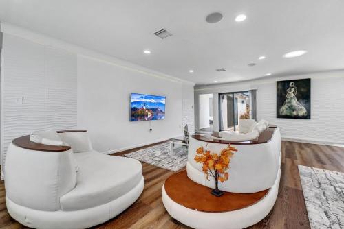 a living room with two white chairs and a table at Luxury 4 bedroom villa in Huntington Beach