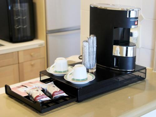 a coffee maker on a stand with cups and plates at Villa The Club 御殿場ウエスト in Gotemba