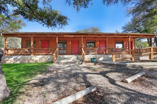 a large log cabin with red doors at Wimberley Log Cabins Resort and Suites- Unit 6 in Wimberley