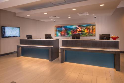 a lobby with a waiting room with a large painting on the wall at Fairfield Inn & Suites by Marriott Altoona in Altoona
