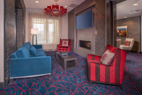a living room with a blue couch and two red chairs at Fairfield Inn & Suites by Marriott Altoona in Altoona