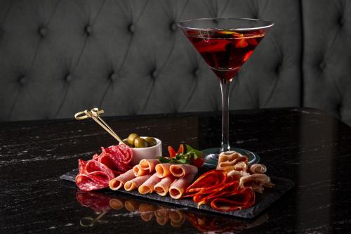 a plate of food and a glass of wine on a table at Casa Malí by Dominion Boutique Hotel in Mexico City