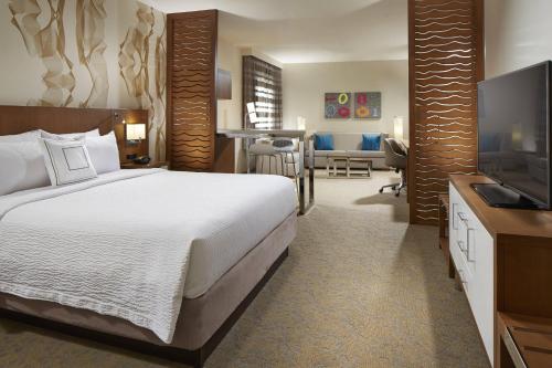 a hotel room with a bed and a television at Courtyard by Marriott Sunnyvale Silicon Valley in Sunnyvale