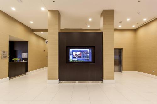 a lobby with a tv on a wall at Courtyard by Marriott Montreal West Island/Baie D’Urfe in Baie-dʼUrfé