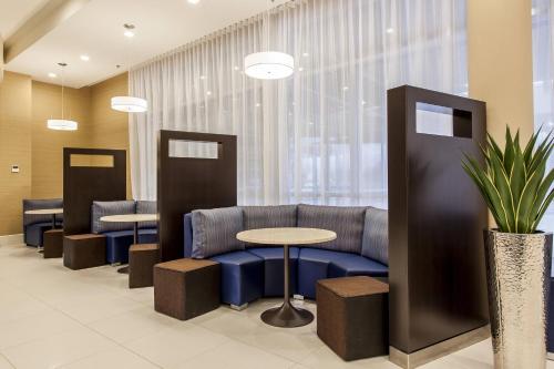 a waiting room with a couch and a table at Courtyard by Marriott Montreal West Island/Baie D’Urfe in Baie-dʼUrfé