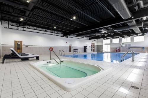 a swimming pool with a large tub in the middle at Courtyard by Marriott Montreal West Island/Baie D’Urfe in Baie-dʼUrfé
