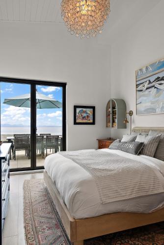 a bedroom with a large bed and a large window at Saratoga Beachfront Villa in Oyster Bay