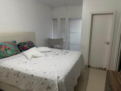 a bedroom with a bed in a white room at Recanto Luna in Foz do Iguaçu