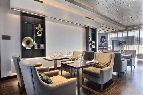 a dining room with tables and chairs and windows at Courtyard by Marriott Quebec City in Quebec City