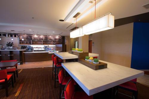 a restaurant with a counter and tables and chairs at Courtyard Blacksburg in Blacksburg