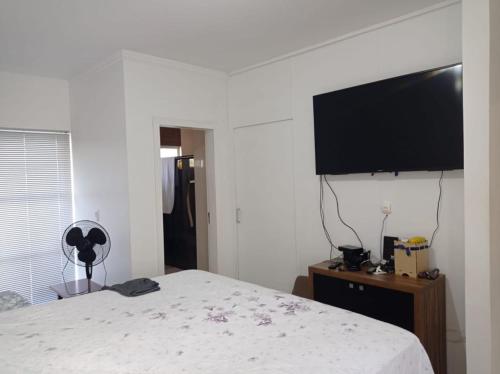 a bedroom with a bed and a flat screen tv at Recanto Luna in Foz do Iguaçu