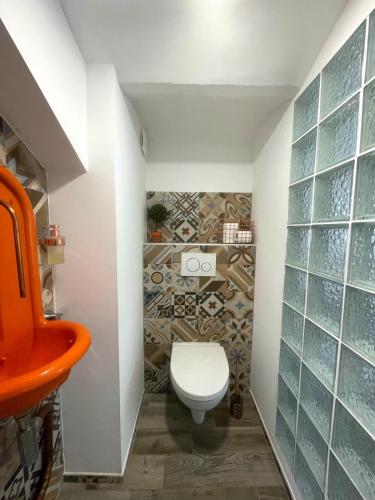 La salle de bains est pourvue de toilettes et d'un mur en verre. dans l'établissement Appartement T3 Nîmes Centre, à Nîmes