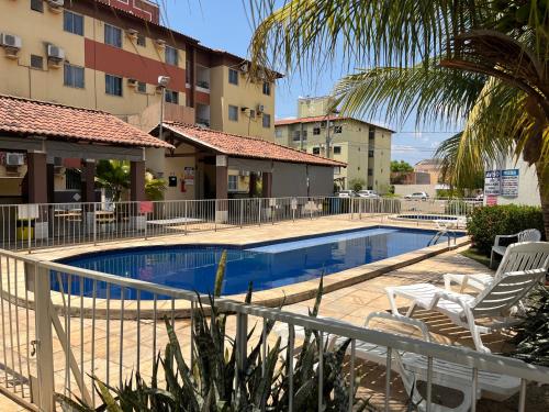 a swimming pool with two chairs and a hotel at Ap com ar condicionado, cozinha equipada, piscina in Imperatriz
