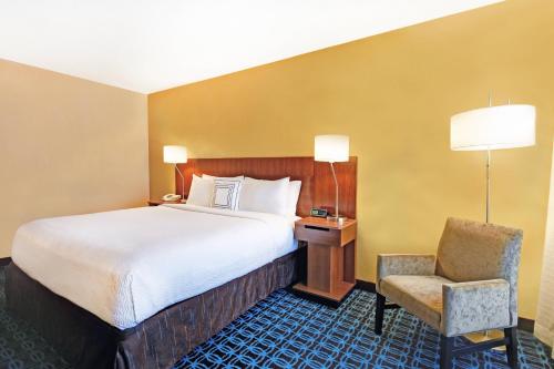 a hotel room with a bed and a chair at Fairfield Inn & Suites by Marriott Atlanta Vinings/Galleria in Atlanta