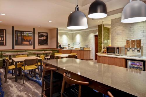 a restaurant with a bar and tables and chairs at Fairfield Inn & Suites by Marriott Atlanta Kennesaw in Kennesaw