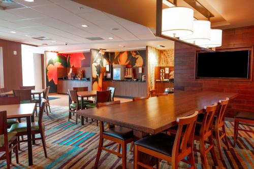 Una sala de conferencias con una gran mesa y sillas de madera. en Fairfield Inn & Suites by Marriott Atlanta Woodstock, en Woodstock