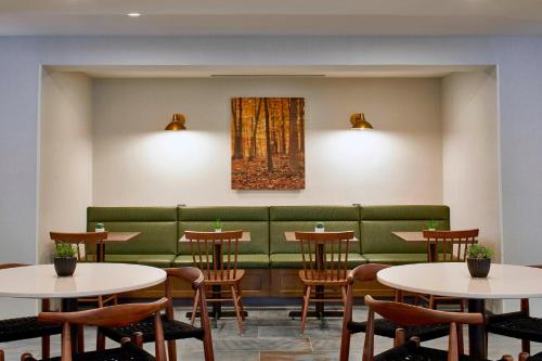 a restaurant with tables and a green couch at Fairfield Inn & Suites by Marriott Albany Airport in Albany