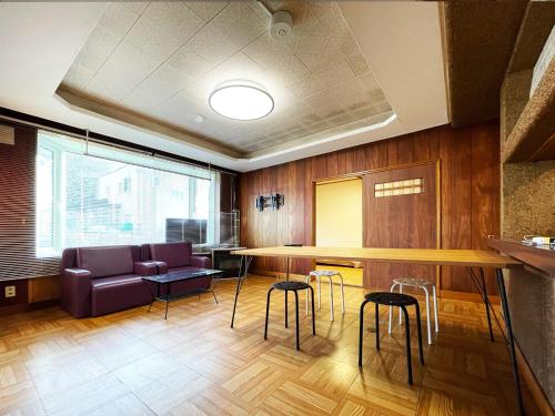 a room with a bar with stools and a table at 佐呂間若佐Arun別邸 in Bushi