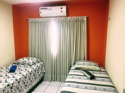 two beds sitting next to each other in a room at Impera House 2 km do centro in Imperatriz