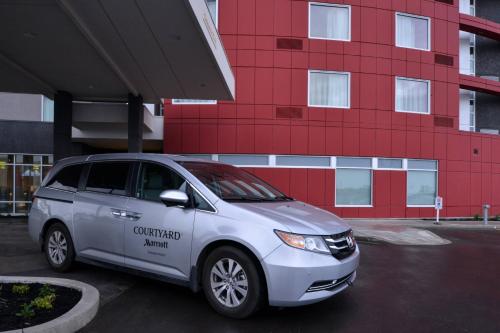 a car parked in a parking lot in front of a red building at Courtyard by Marriott Saskatoon Airport in Saskatoon
