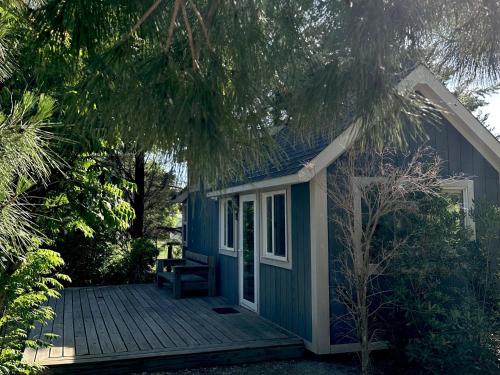 a small blue house with a wooden deck at Tiny House Mercedes in Mercedes