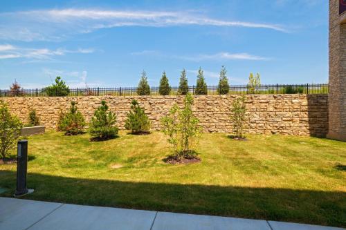 a stone wall with plants in a yard at Courtyard St. Louis Brentwood in Richmond Heights