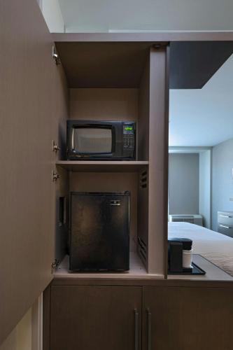 a small kitchen with a microwave and a television at Courtyard St. Louis Brentwood in Richmond Heights