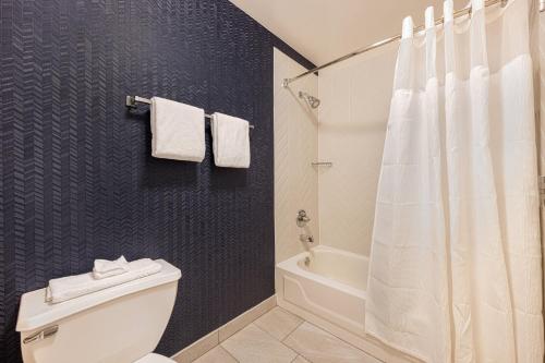 a bathroom with a white toilet and a shower at Fairfield Inn & Suites by Marriott Chicago Naperville in Naperville