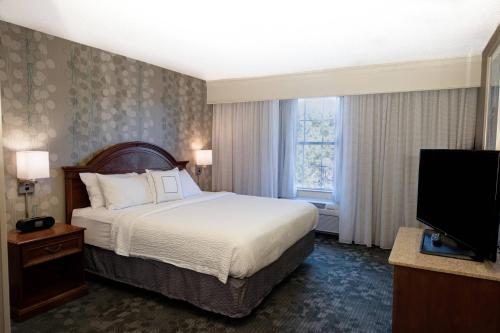 a hotel room with a bed and a television at Courtyard Chapel Hill in Chapel Hill